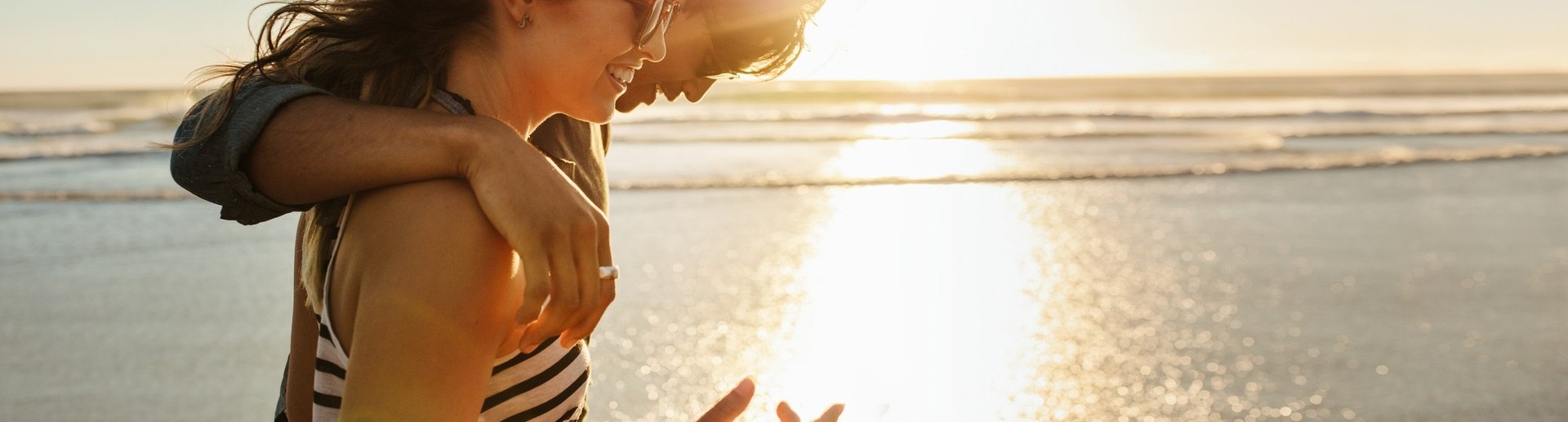 Photographie d'un couple se prenant par la main devant la mer